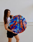 Load image into Gallery viewer, Person holding a large colorful basketball against a white background
