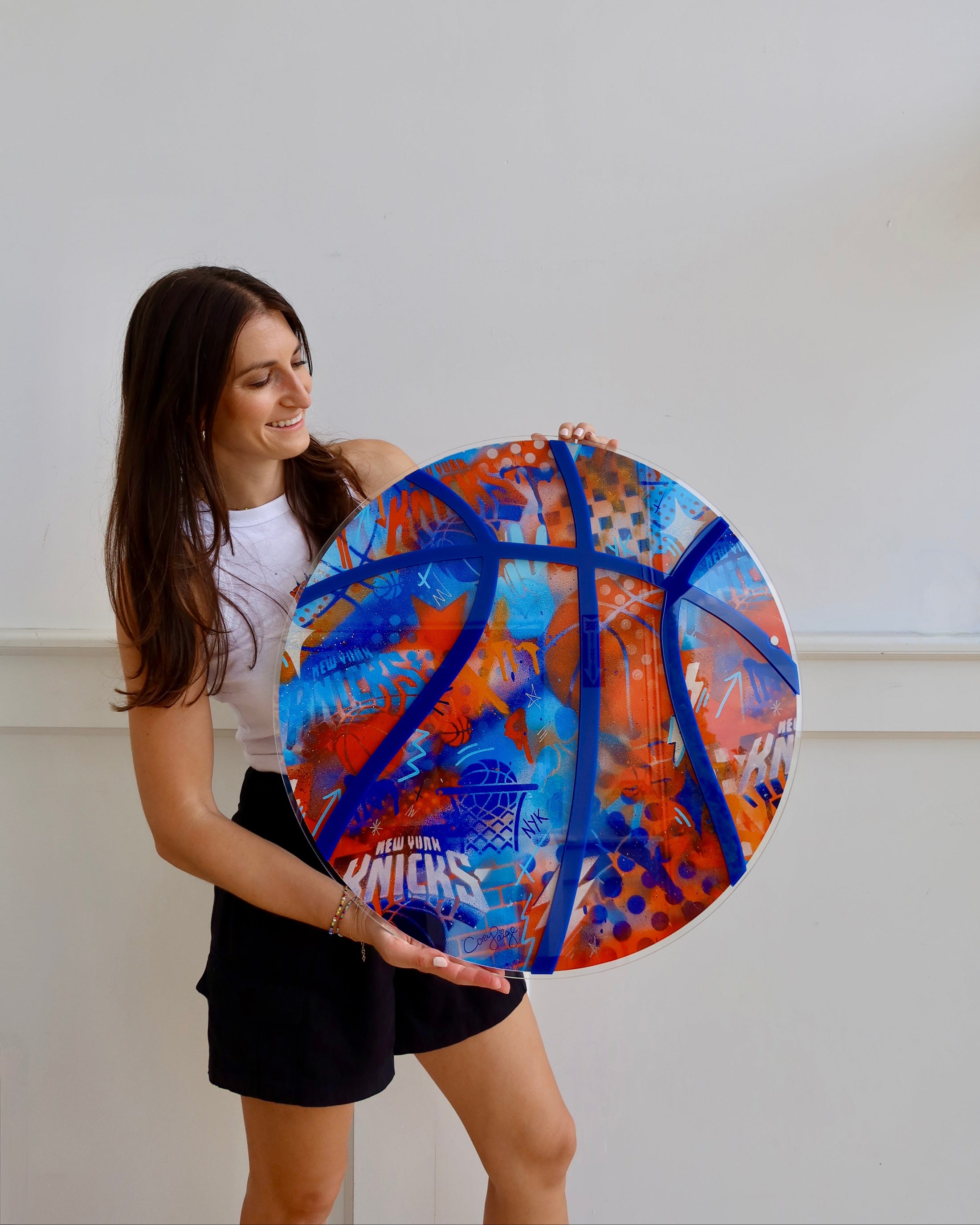 Person holding a large colorful basketball against a white background